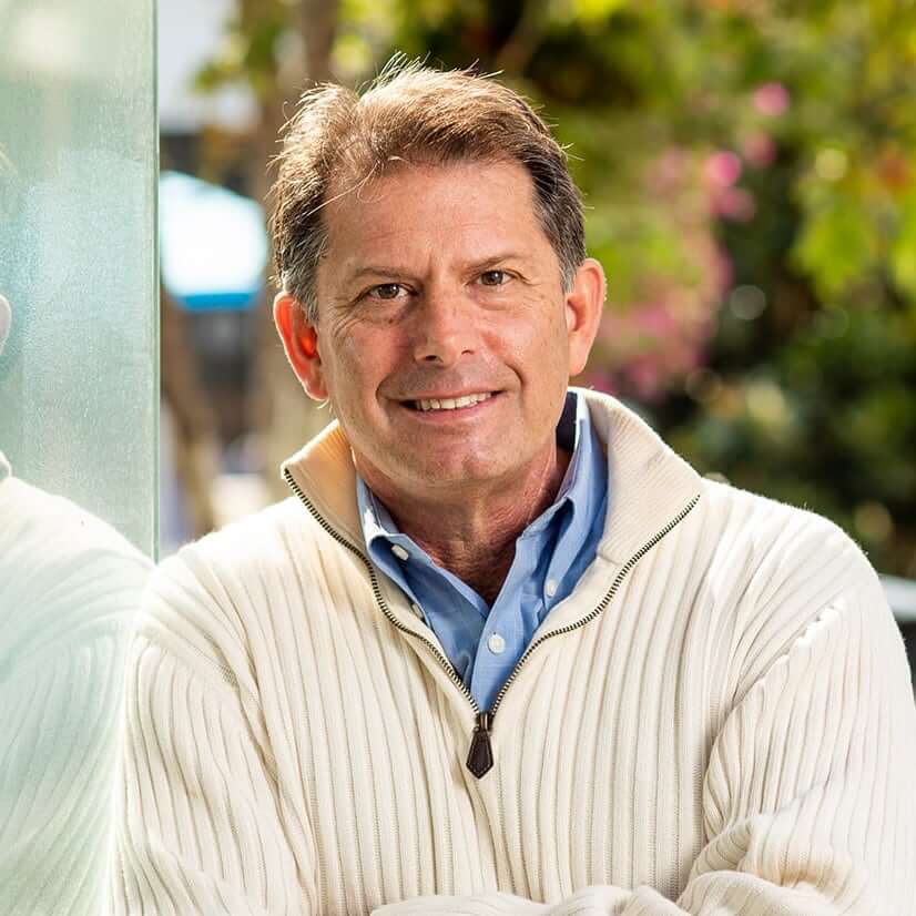 A portrait of Edouard Knighton, CMT smiling with arms folded